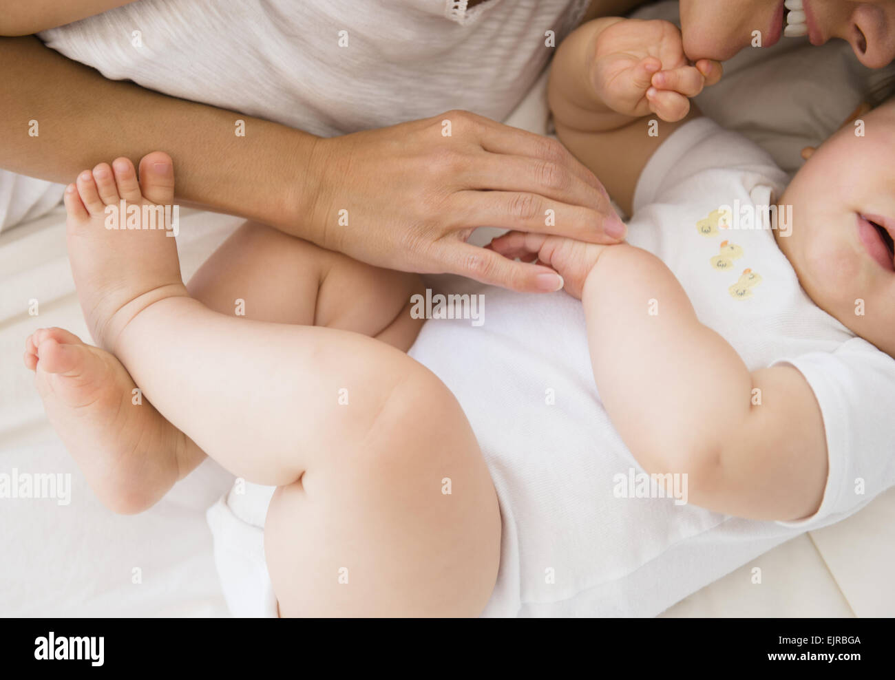 Vista aérea de raza mixta madre sentar con el bebé en la cama Foto de stock