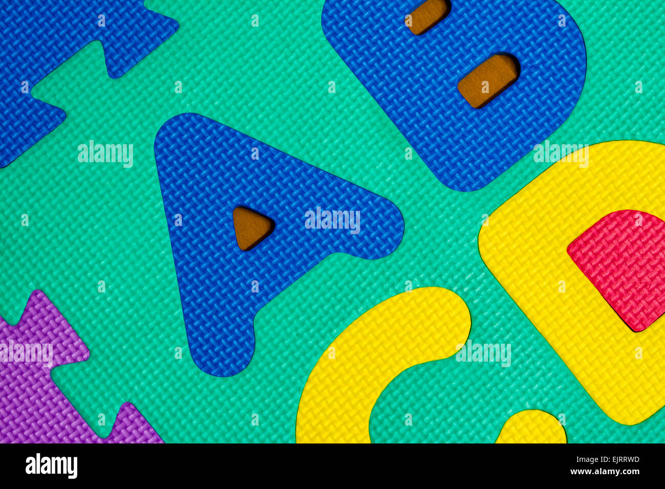 Unas pocas cartas de un colorido puzzle ABC de espuma. Foto de stock