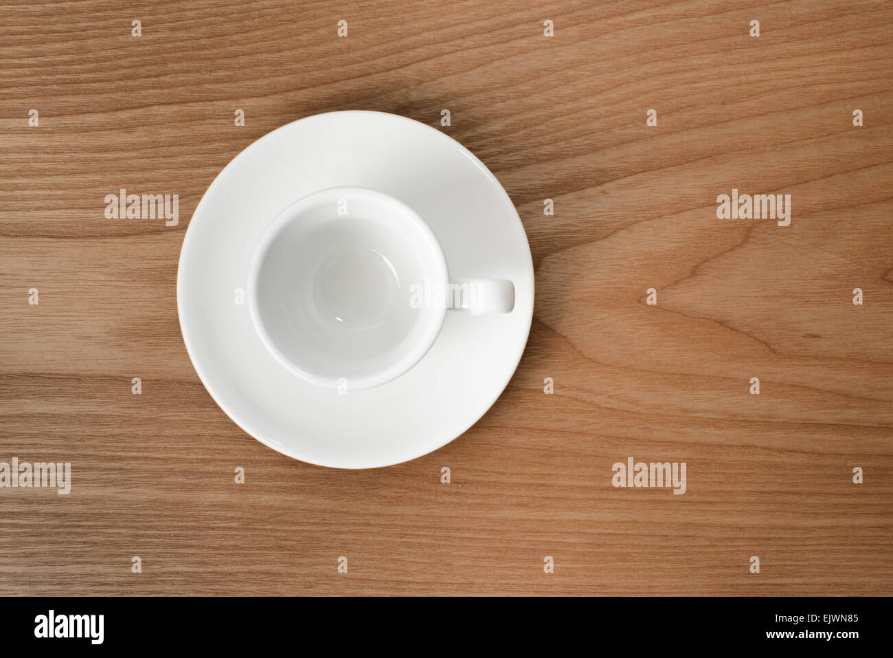 Taza de café blanco vacío sobre una placa de madera Foto de stock
