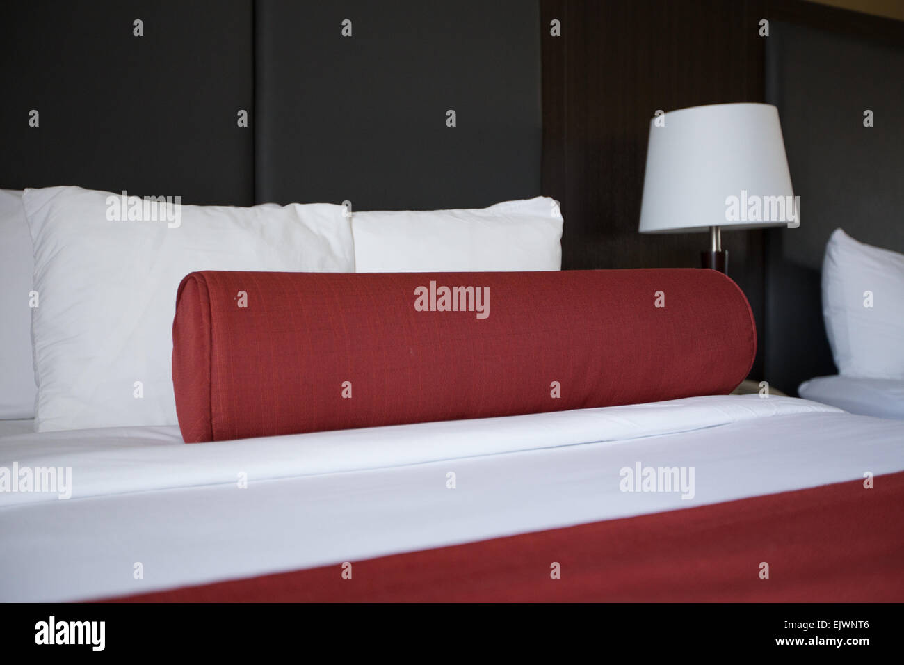 Rodillo rojo almohada hotel cama Foto de stock