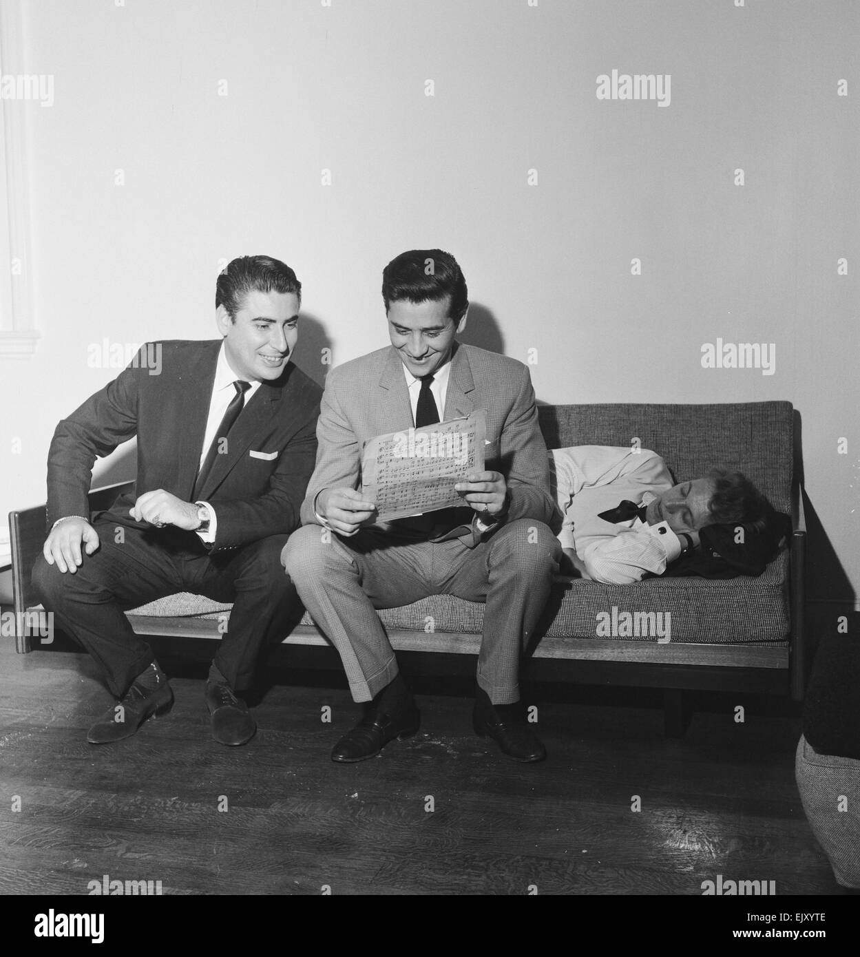 Larry Parnes (izq.) y John Kennedy (centro), gestores de la cantante Tommy Steele, quien es retratada durmiendo en el sofá, 28 de abril de 1961. *** Título Local *** Lawrence Parnes Manager Foto de stock