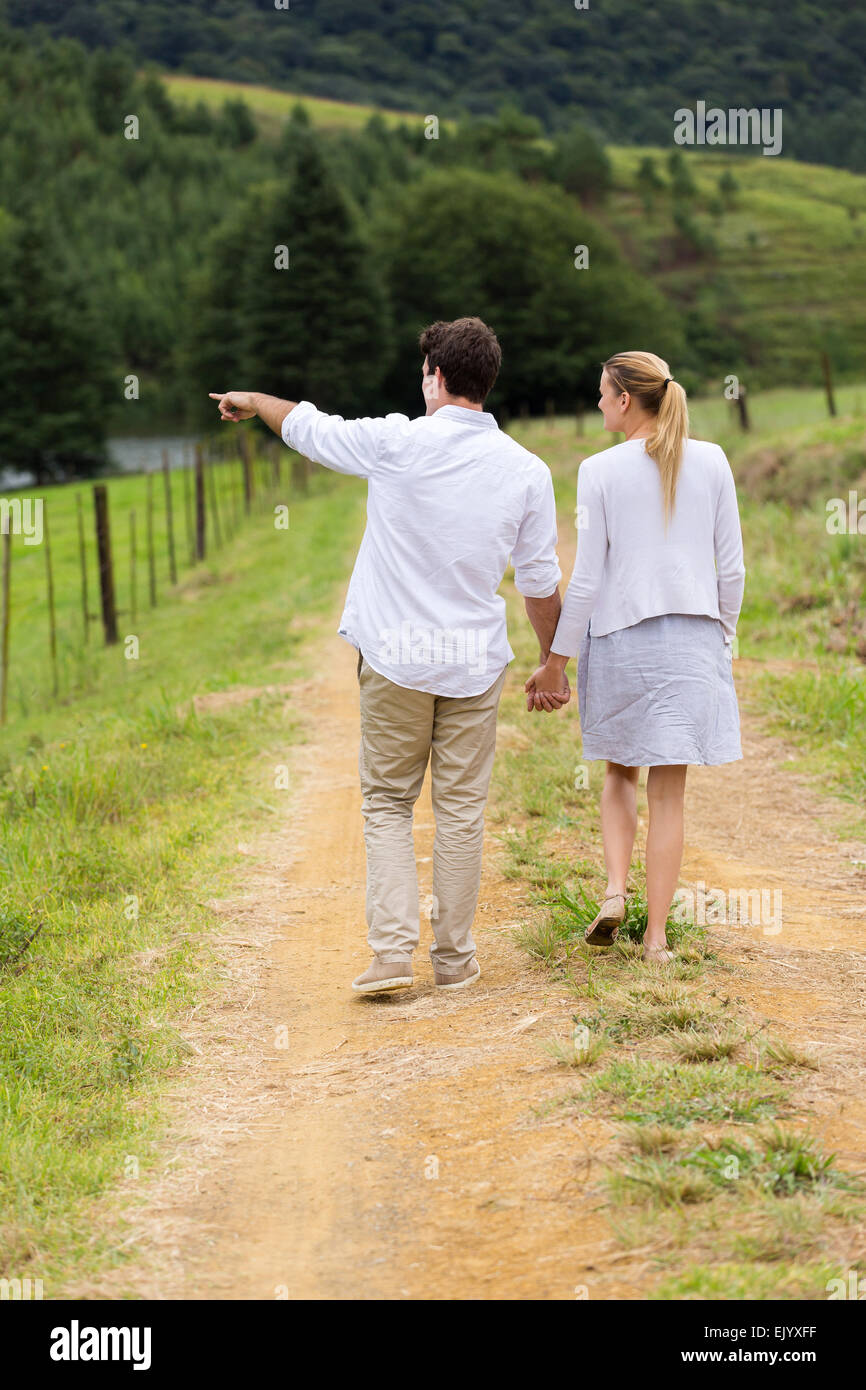 Vista trasera de la joven pareja caminando en Country Road Foto de stock