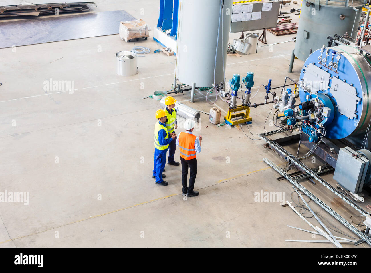 Equipo industrial de trabajador y el ingeniero discutiendo en la máquina en la fábrica. Foto de stock
