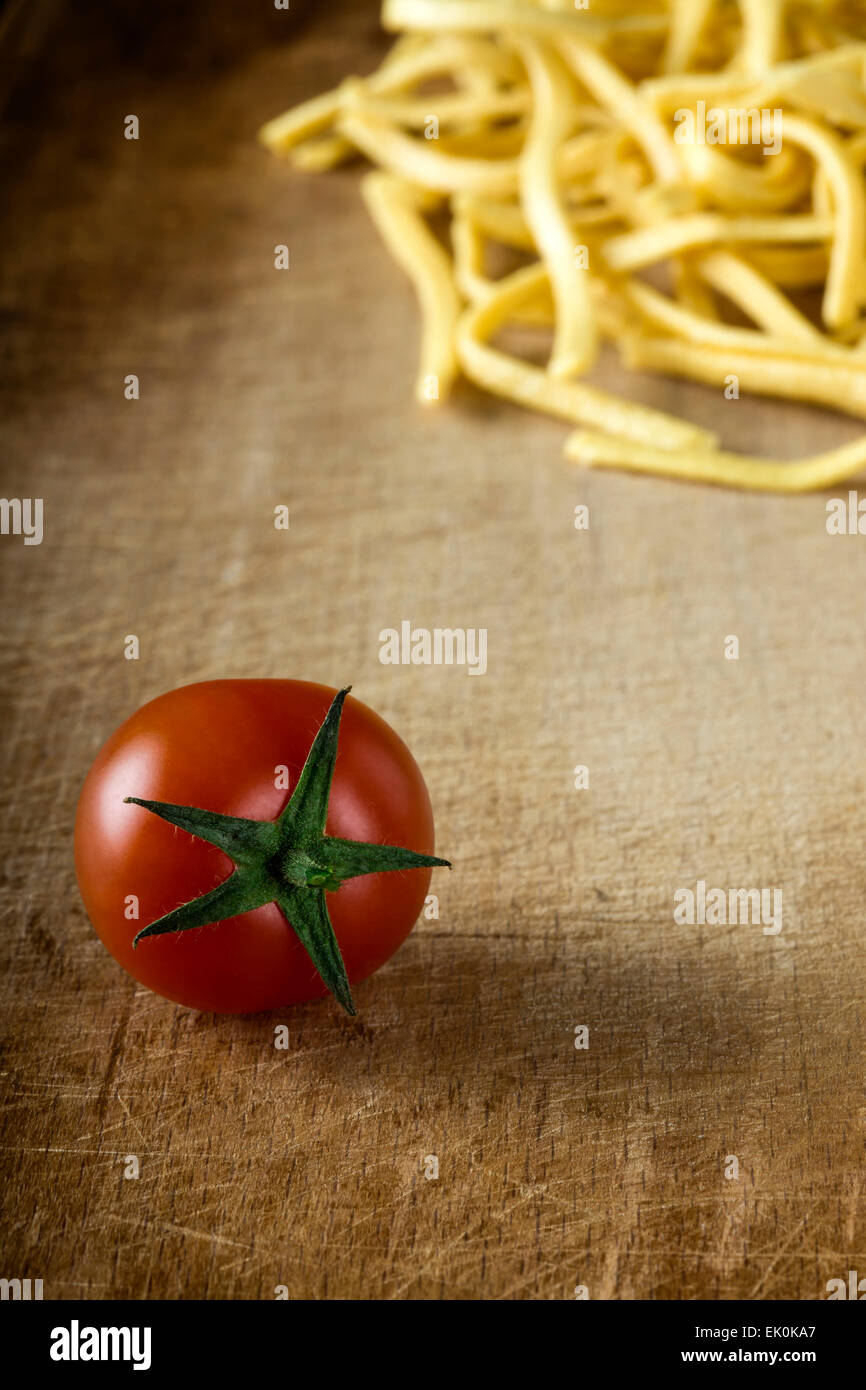 Tomate y fideos sobre fondo de madera vieja Foto de stock