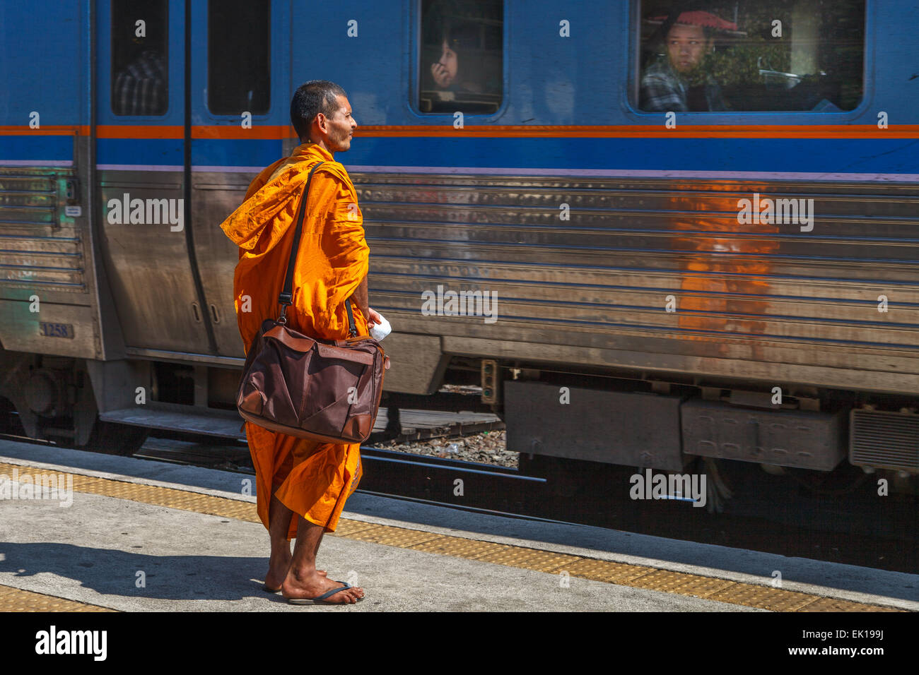 Monje tailandés mientras toma un tren a la estación de ferrocarril de Ayutthaya, Tailandia. Foto de stock
