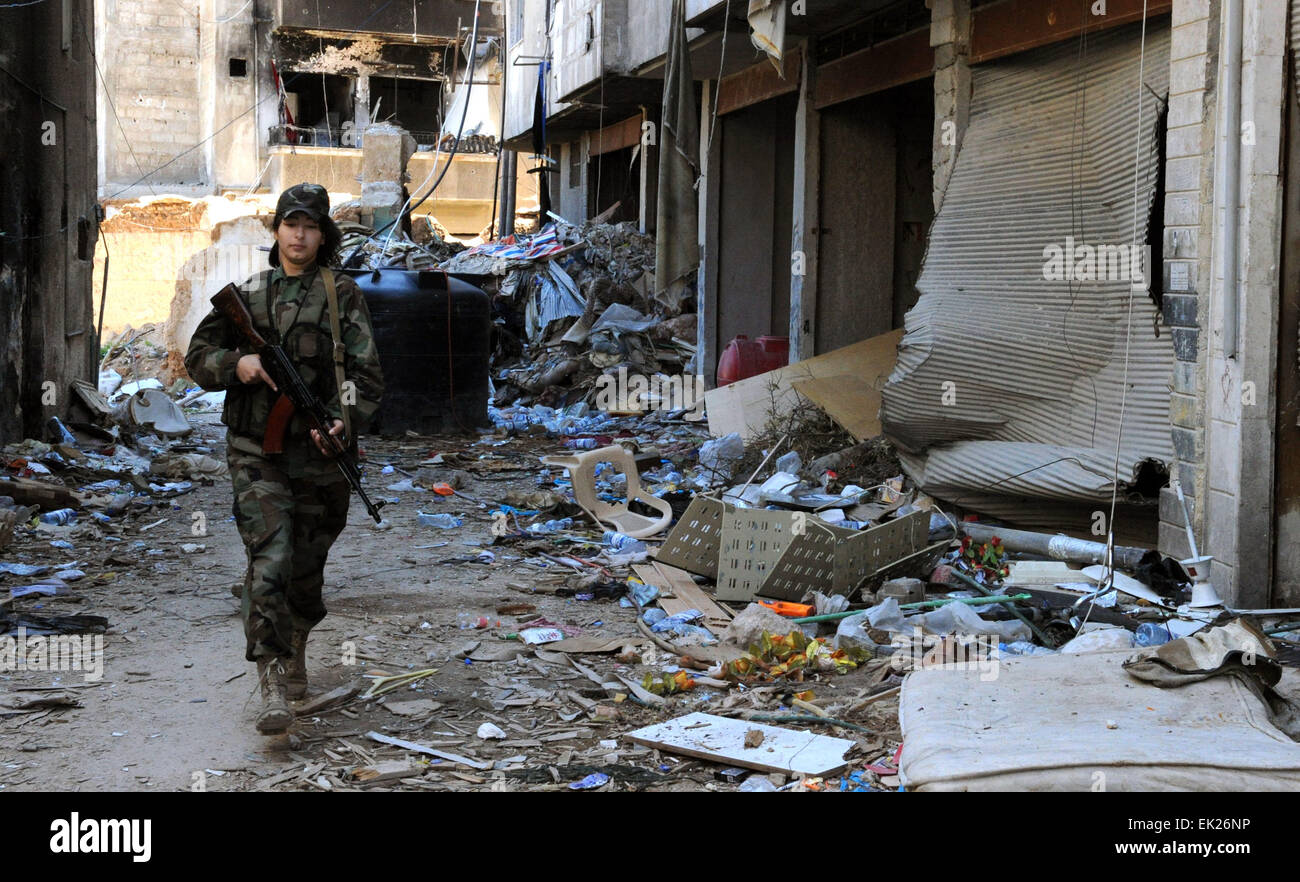 Damasco, Siria. 5 abr, 2015. Un francotirador femenina patrullas en Daraya suburbio de la capital, Damasco, Siria, el 5 de abril de 2015. Los francotiradores son miembros de la fuerza femenina en República Guardia Republicana. La unidad se compone de alrededor de 800 voluntarios, solteras, mujeres combatientes- con edades comprendidas entre los 20 y 24 años de edad. Su tarea es la de trabajar junto al ejército sirio en su lucha contra los rebeldes. © Zhang Naijie/Xinhua/Alamy Live News Foto de stock