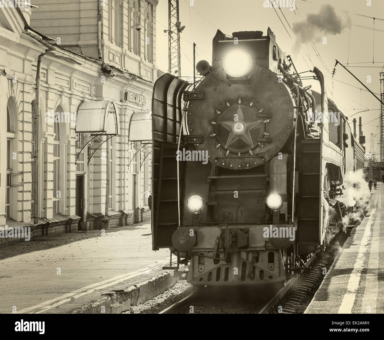 Retro llega el tren de vapor a la estación. Imagen Vintage. Foto de stock