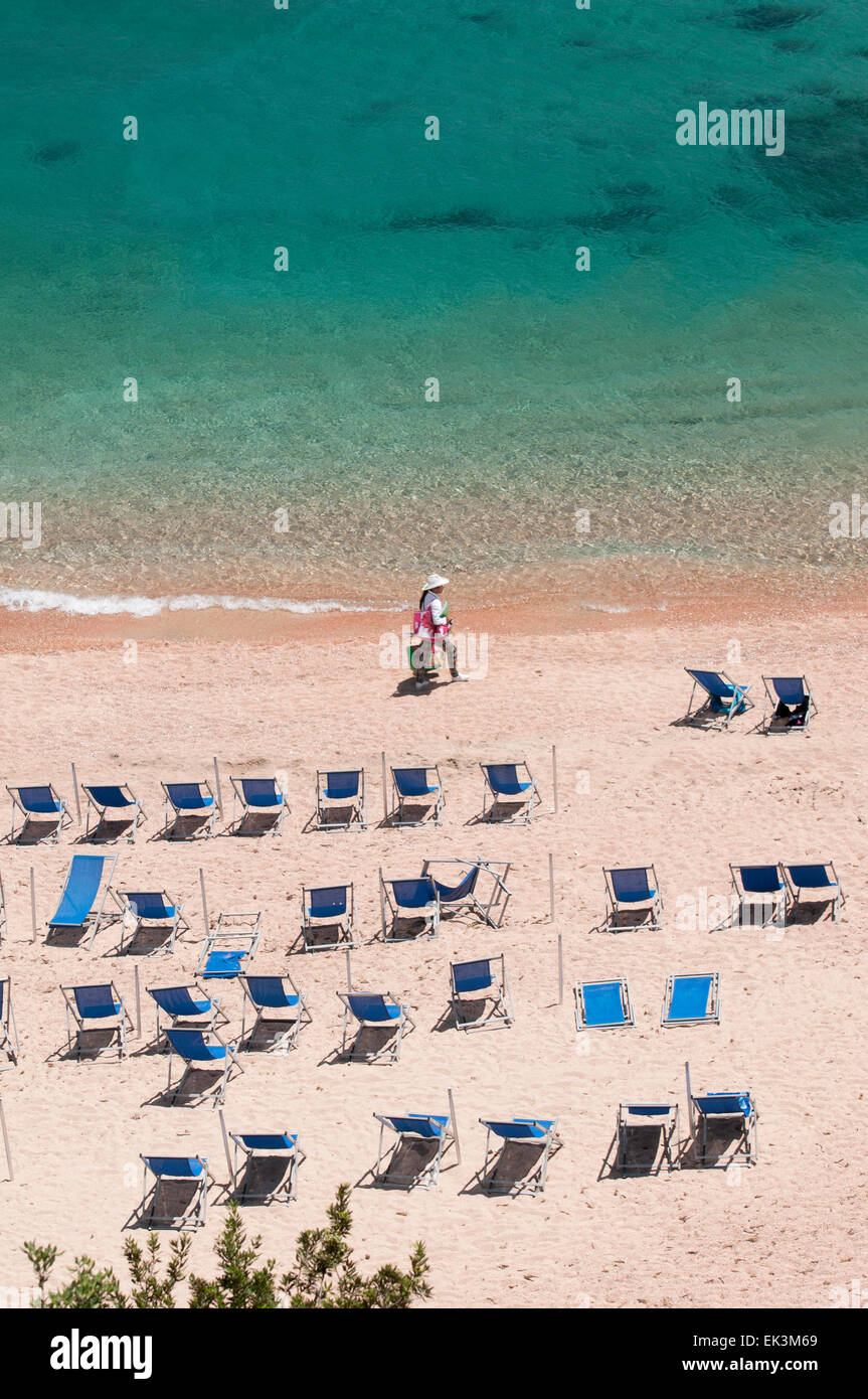 Cala Gonone, Cerdeña, Italia, 6/2012. La mujer disfruta de la soledad y el mar en un día de verano en la playa Foto de stock