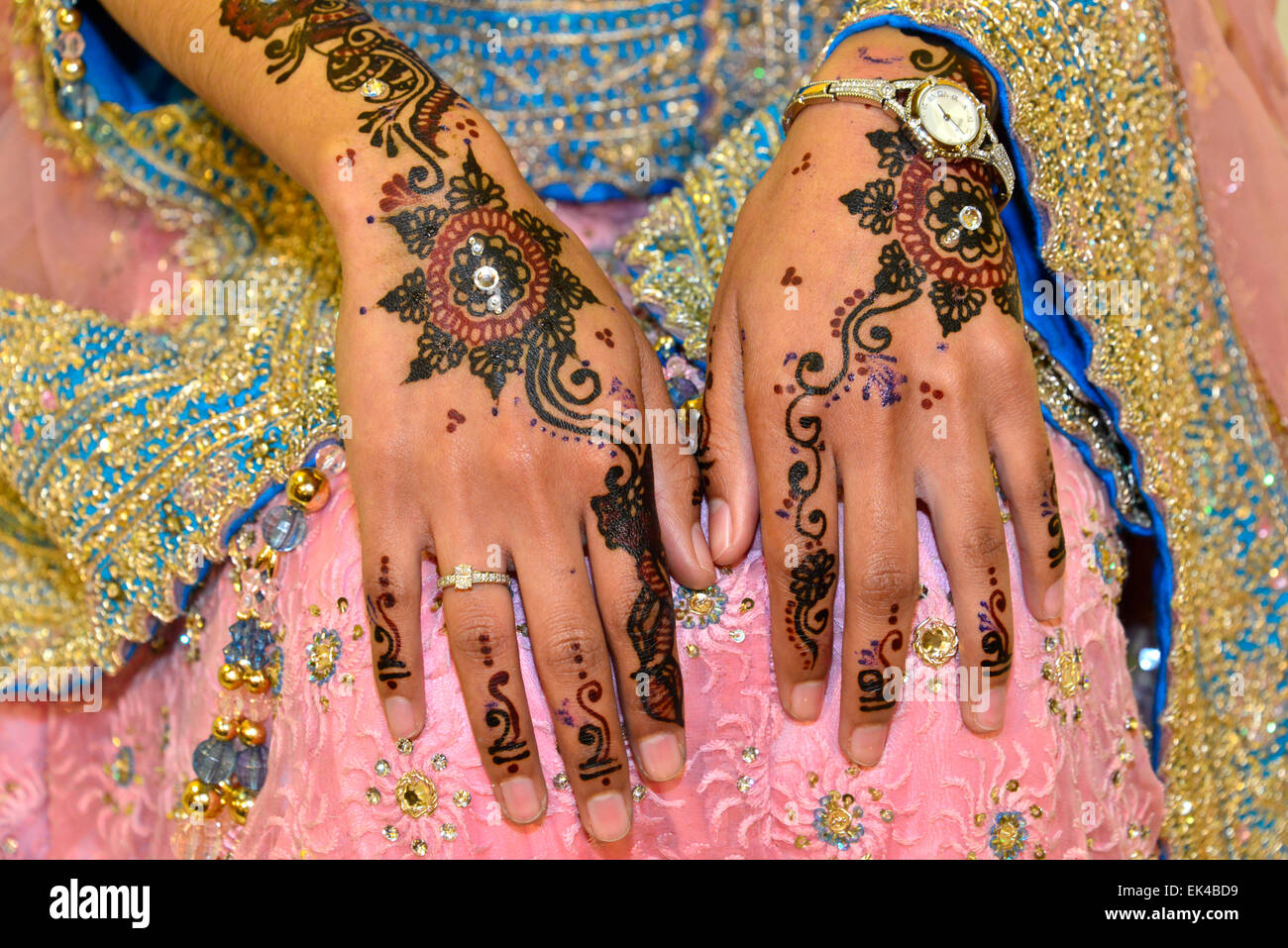 Henna y joyas en las manos de una joven dama en su compromiso. Foto de stock