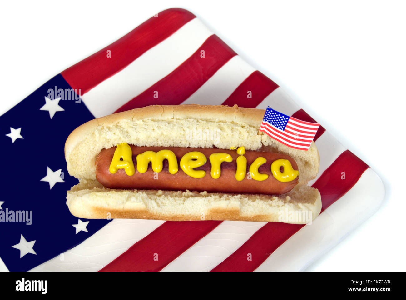 Mostaza en hot dog con bandera americana y la placa aislado en blanco. Foto de stock