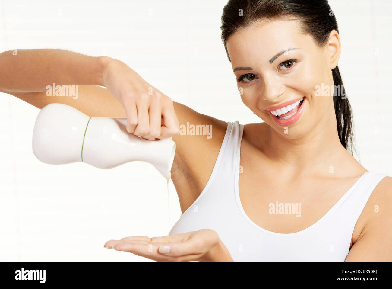 Mujer joven vertiendo aceite de oliva botella de cristal Foto de stock