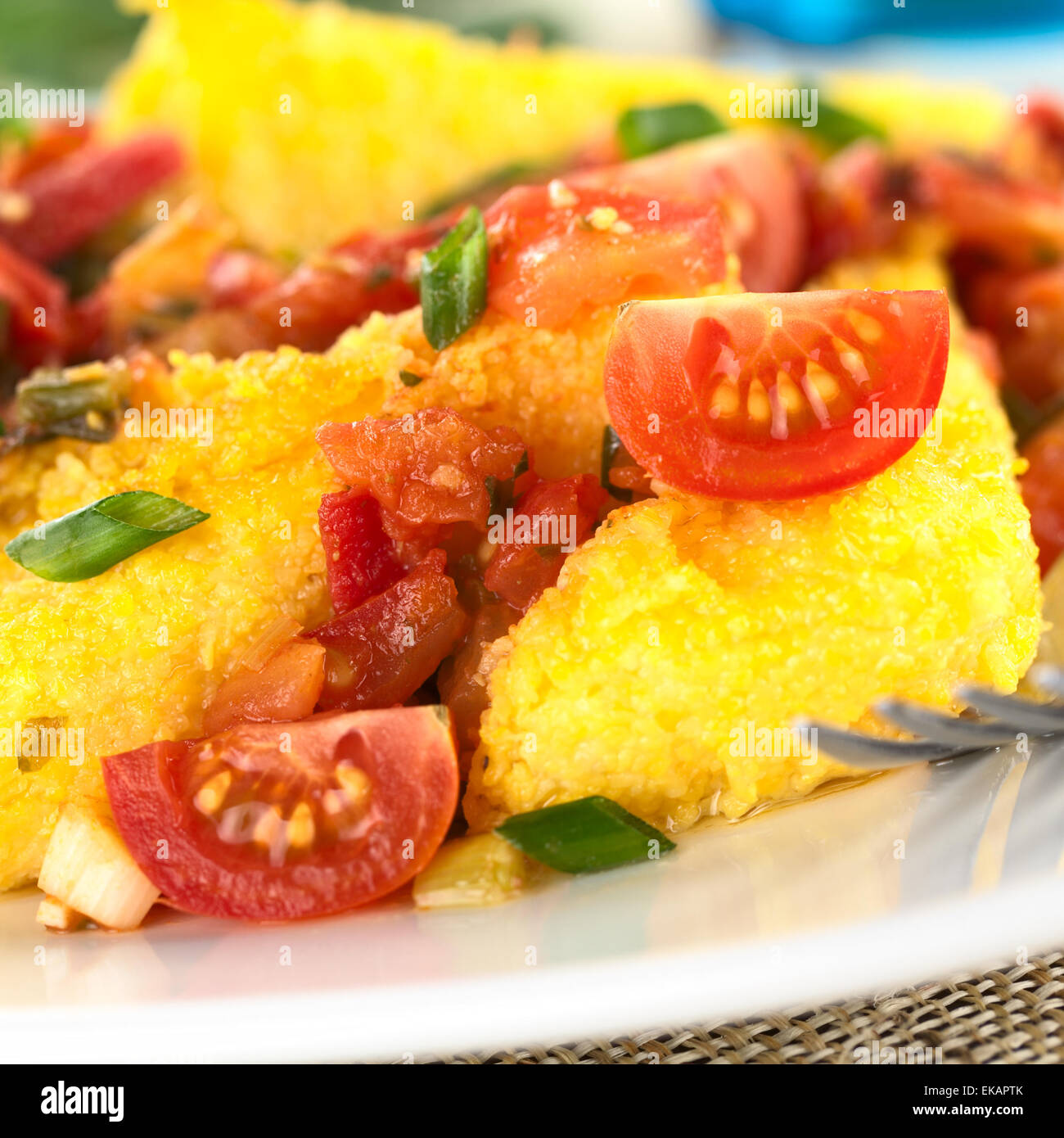 Polenta cortes con Hogao, también llamado salsa criolla colombiana, la cual es una salsa de tomate, cebolla y cilantro. Foto de stock