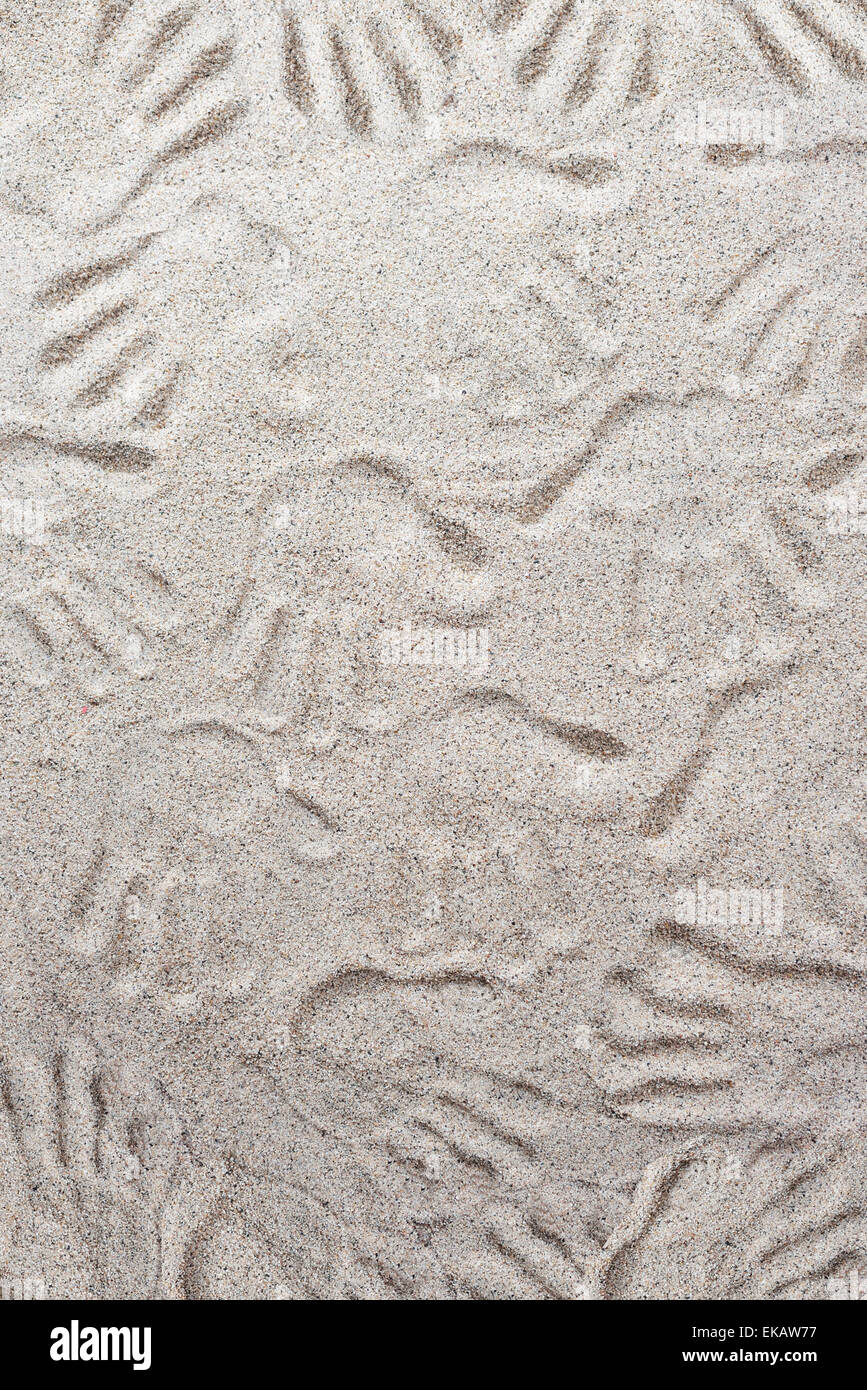 Muchas huellas dactilares sobre un fondo de arena Foto de stock