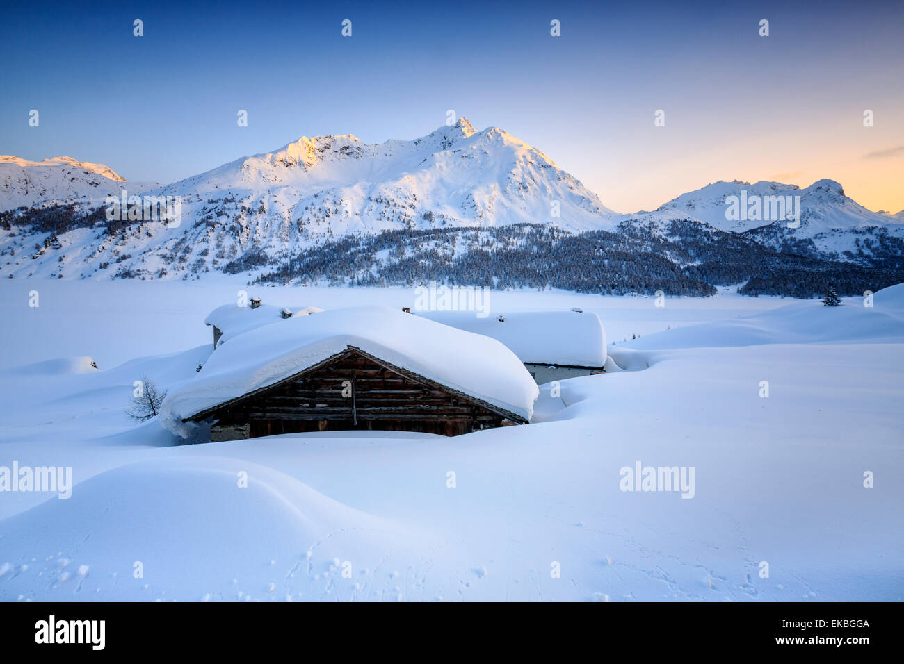 Paisaje nevado en la Spluga Maloja Pass con la magia de los colores de la puesta de sol, Graubunden, Alpes Suizos, Suiza Foto de stock