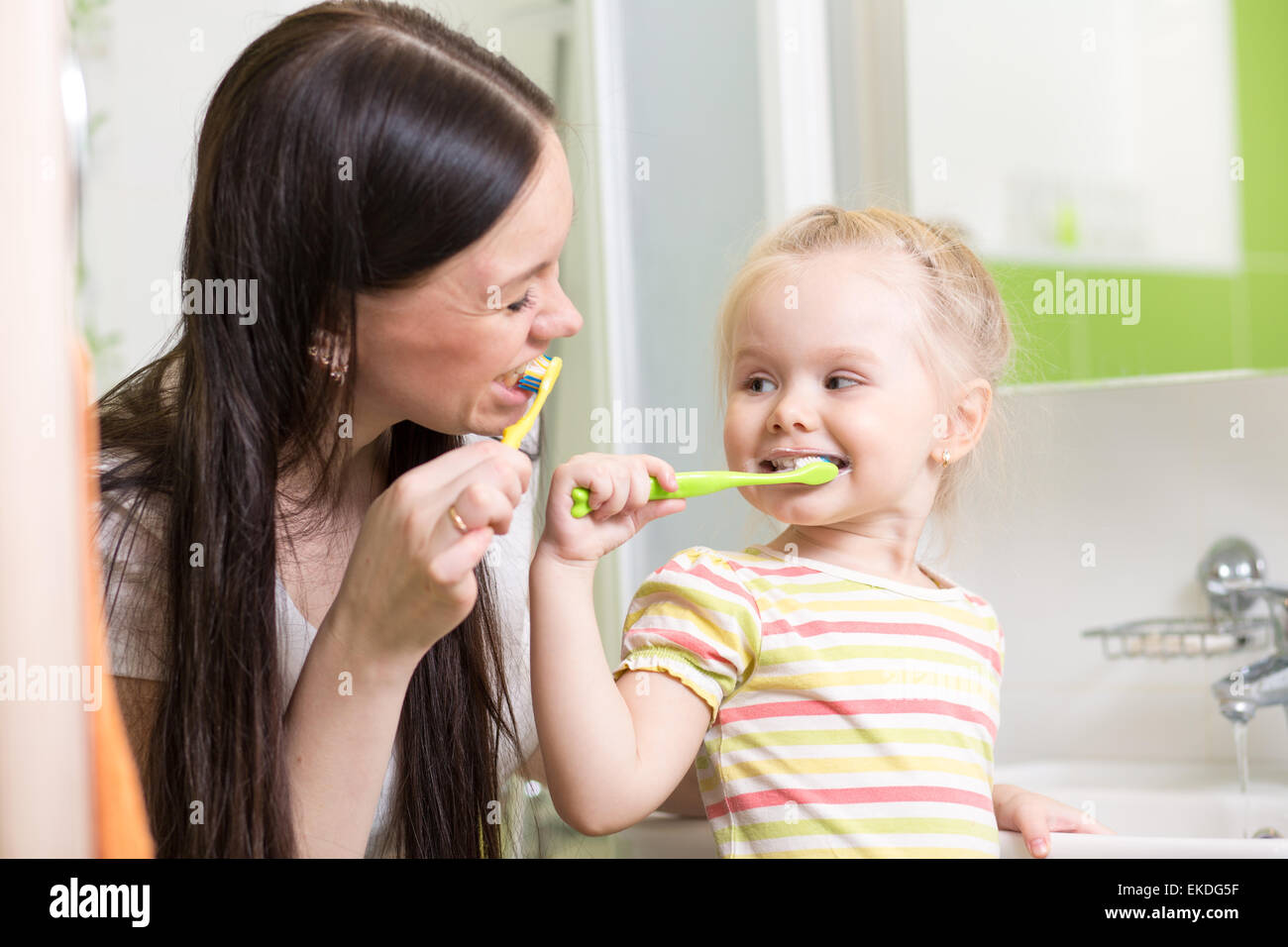 Lindo mom cepillado de dientes infantil docente Foto de stock