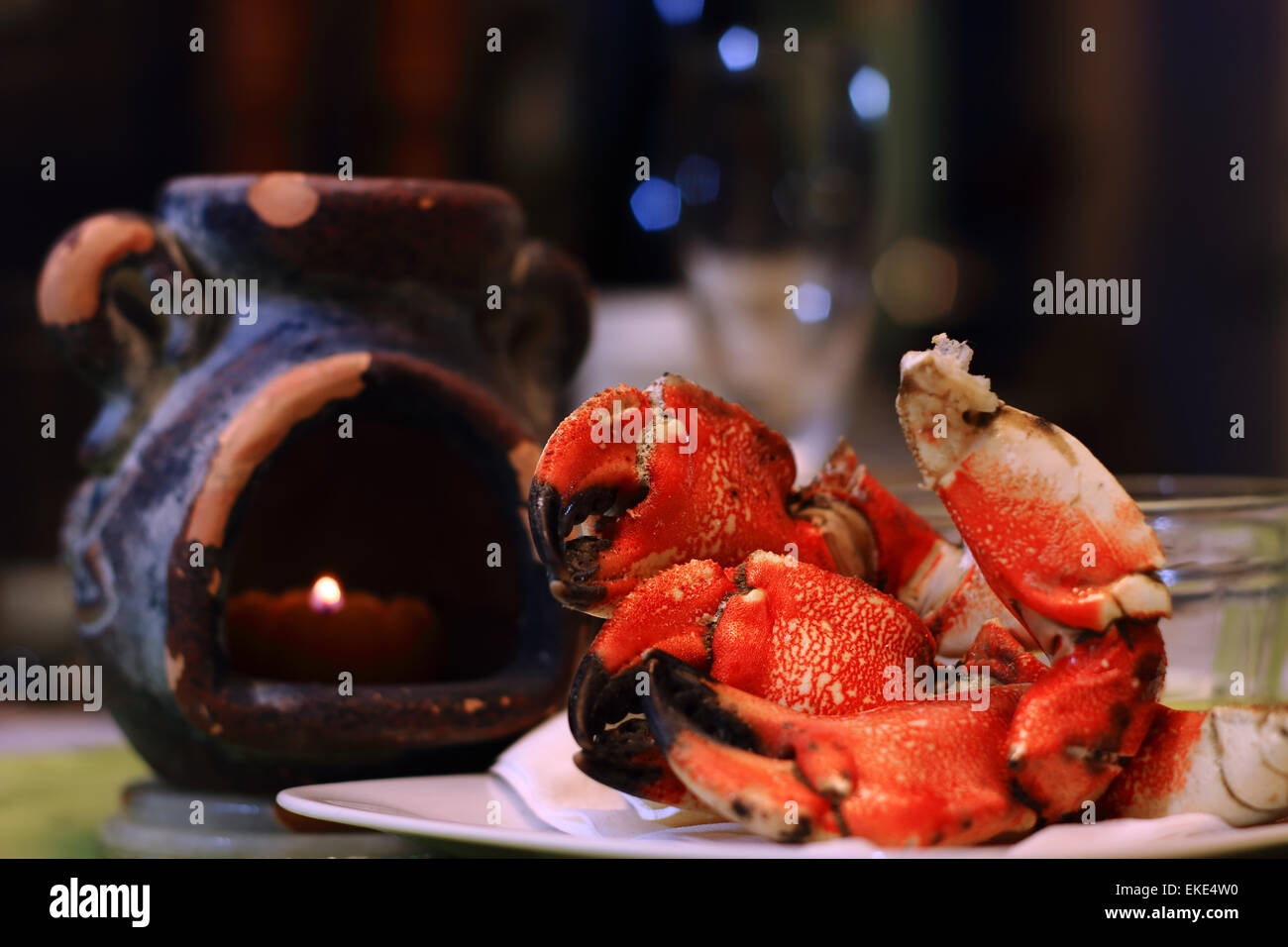 Jonás Cangrejo garras sobre una placa, con luz de velas y defocsed copa de vino en el restaurante. Jonás, cangrejos, aka estiércol Atlántico Foto de stock