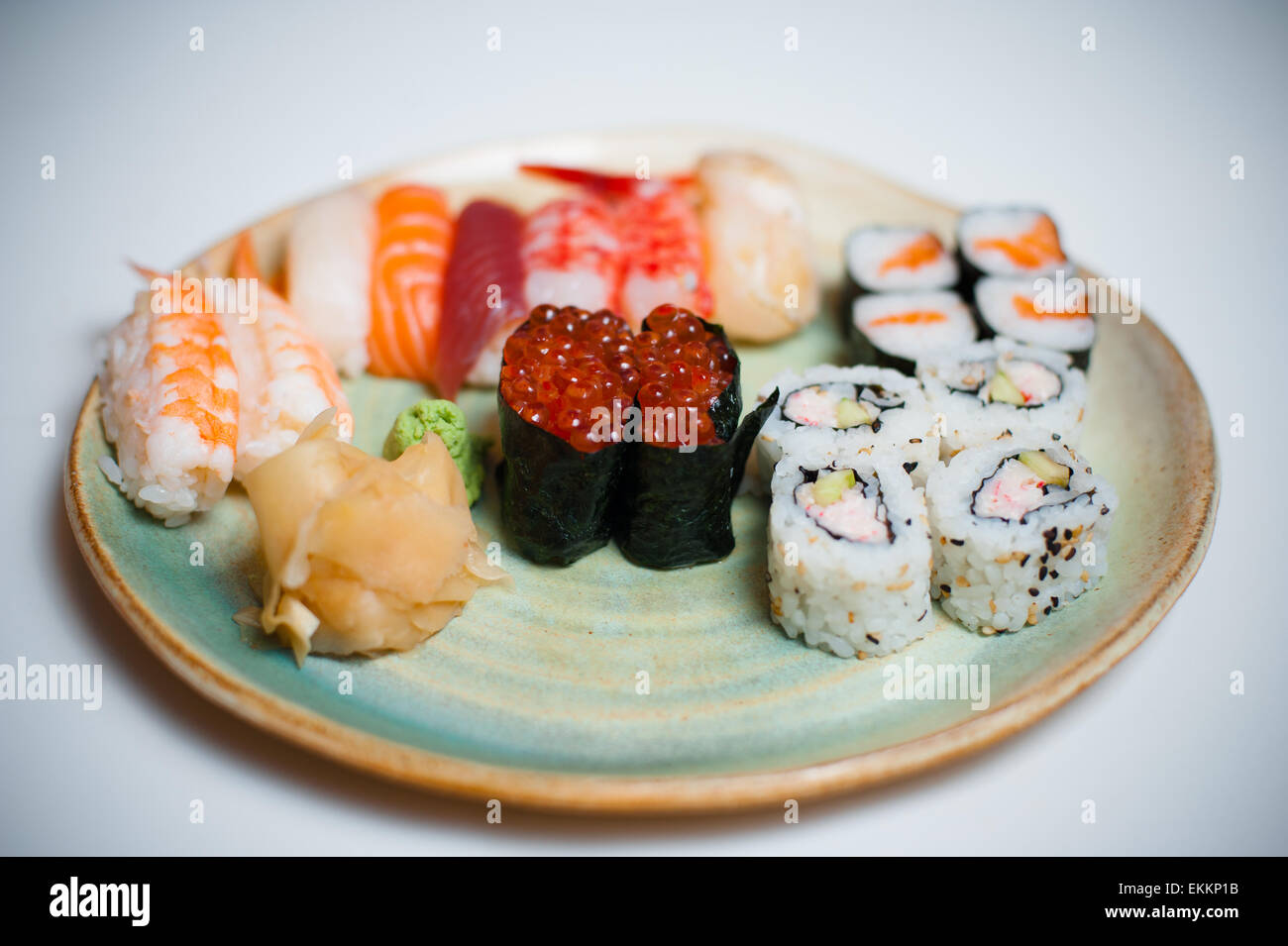 Plato de sushi mixto sobre fondo blanco, el enfoque selectivo en gunkan Foto de stock
