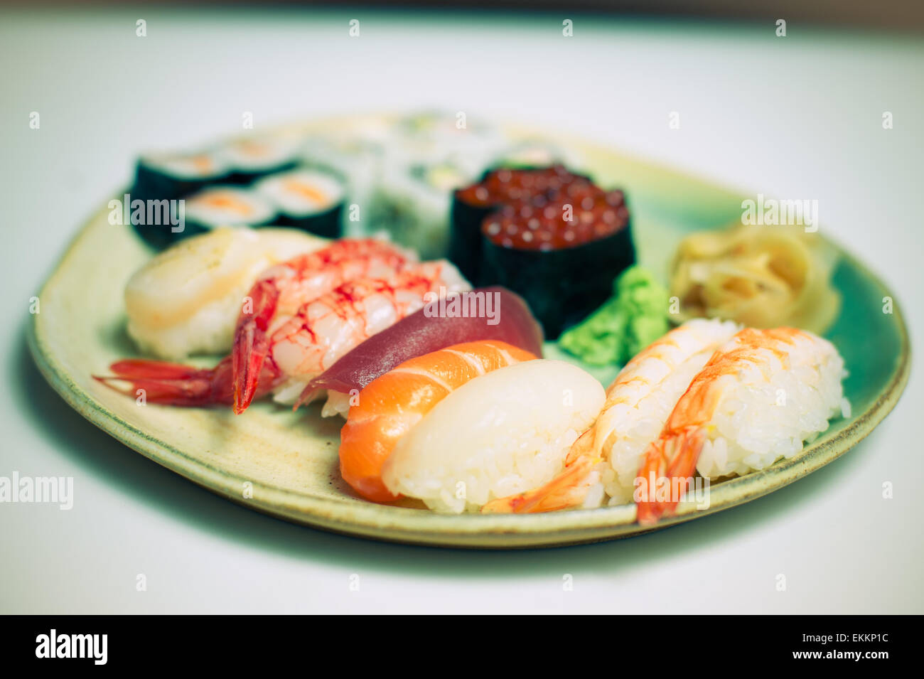 Plato de sushi mixto sobre fondo blanco efecto de color. Foto de stock