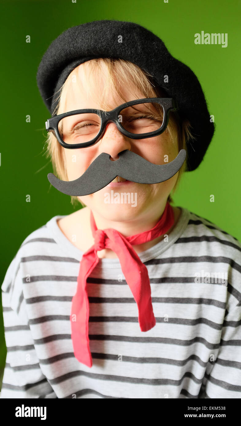 Laughing Niño vestirse para un proyecto de la escuela francesa de día Foto de stock