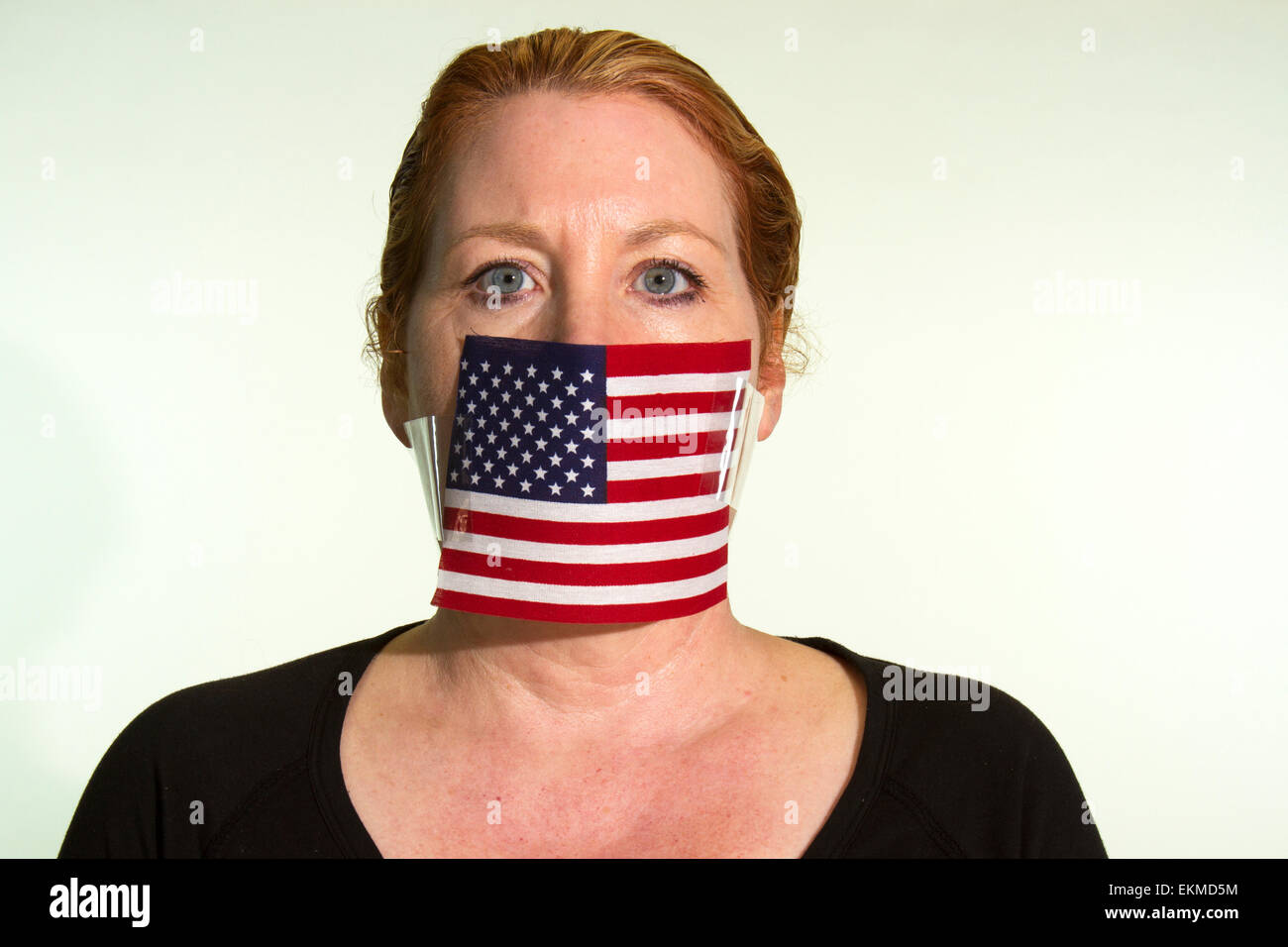La censura por el gobierno de los Estados Unidos expresada por una mujer con una bandera Americana tapado la boca Foto de stock