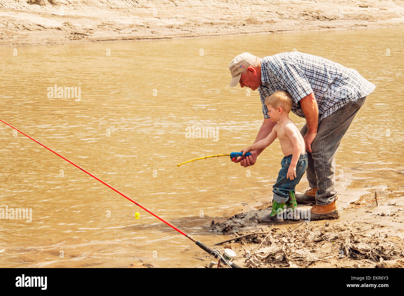 Enseñanza abuelo nieto para pescar con caña y carrete de juguete Foto de stock