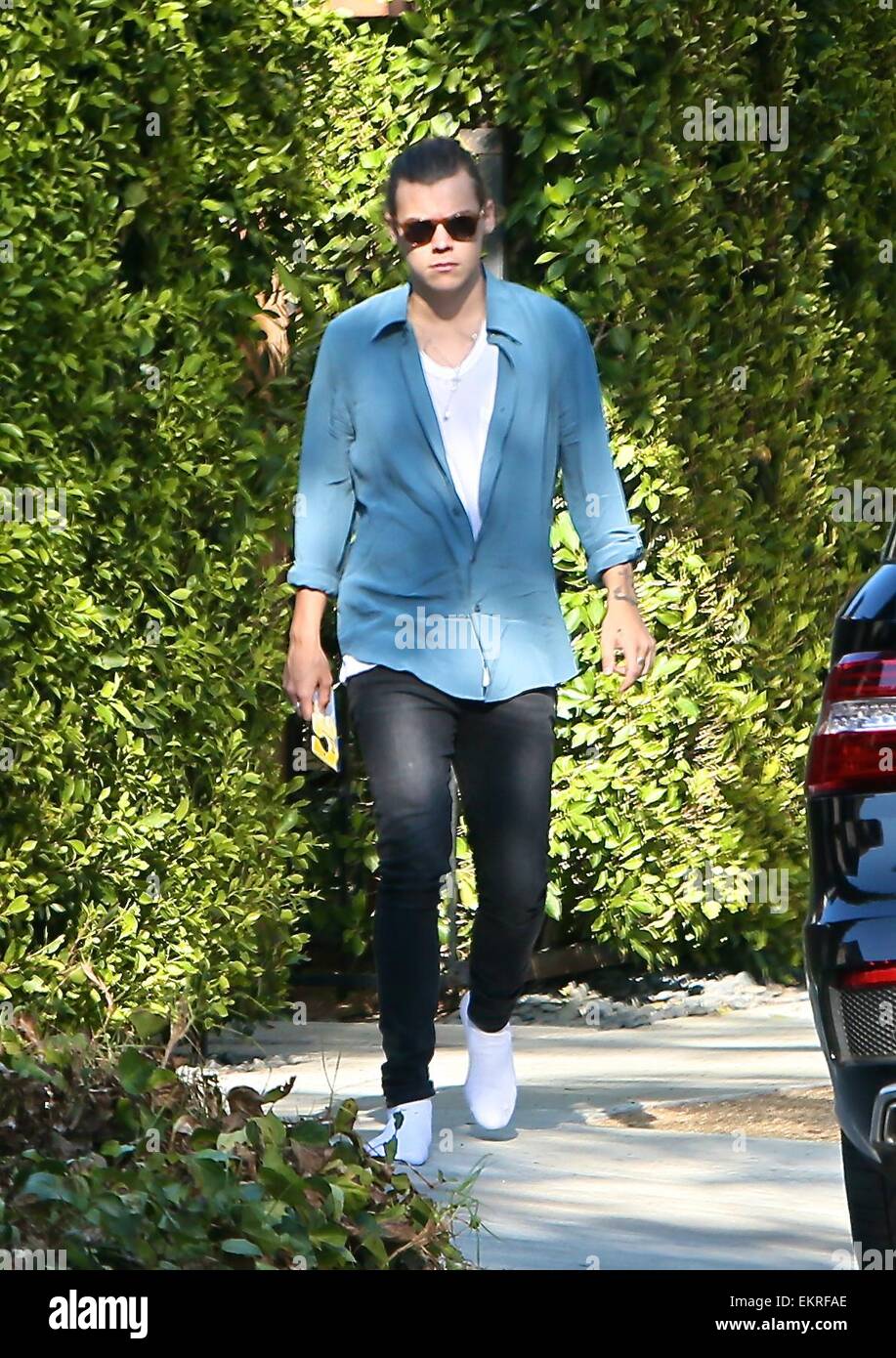 Harry Styles caminando en calcetines blancos y con su cabello amarrado  atrás visto salir de una casa en Beverly Hills con: Harry estilos donde:  Los Angeles, California, Estados Unidos Cuándo: 09 Oct