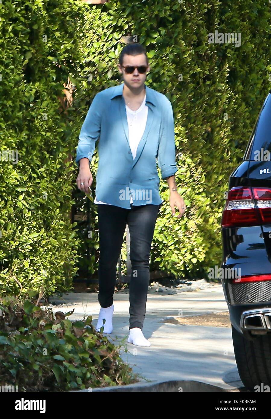 Harry Styles caminando en calcetines blancos y con su cabello amarrado  atrás visto salir de una casa en Beverly Hills con: Harry estilos donde:  Los Angeles, California, Estados Unidos Cuándo: 09 Oct