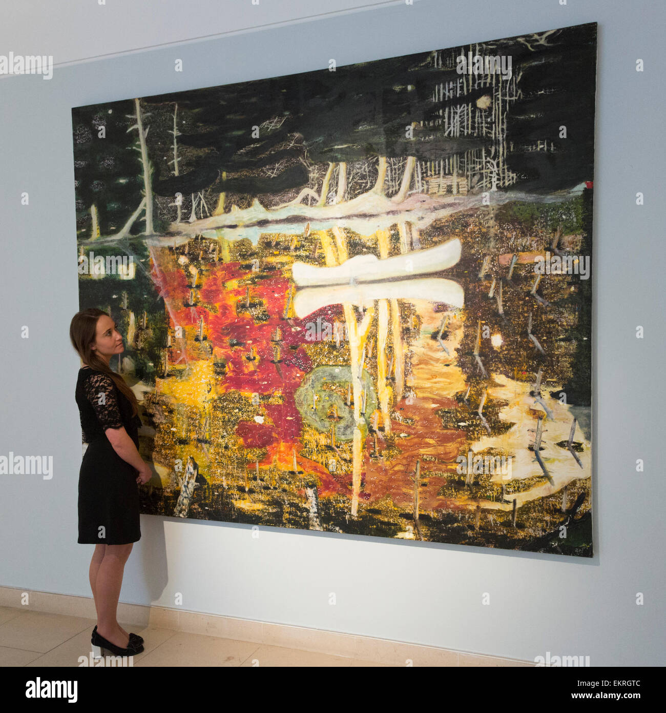 Londres, Reino Unido. 13 de abril de 2015. Un empleado de Christie's mira  el Peter Doig pintura inundada, estimación de US-$20-30m. Christie's exhibe  una selección de casi cincuenta obras procedentes de las