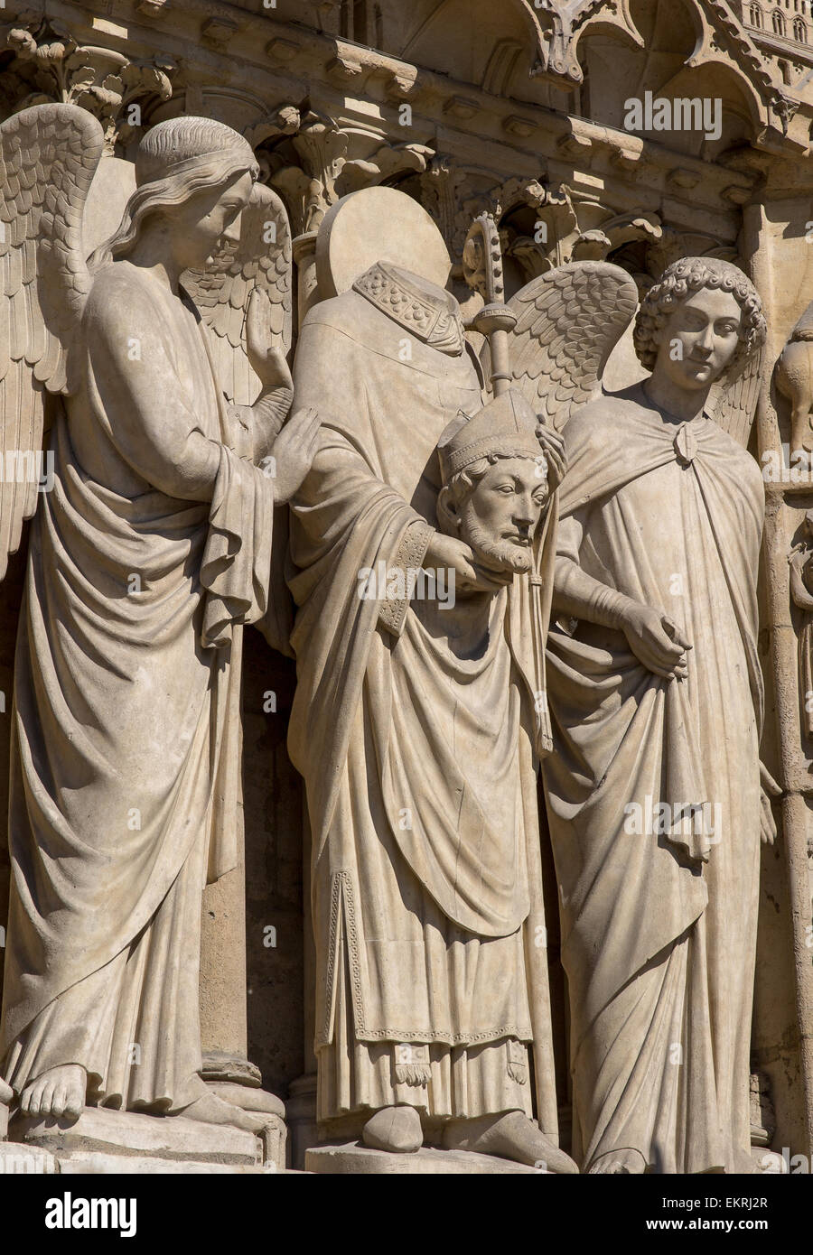 Escultura que representa Saint Denis sosteniendo su cabeza en el portal