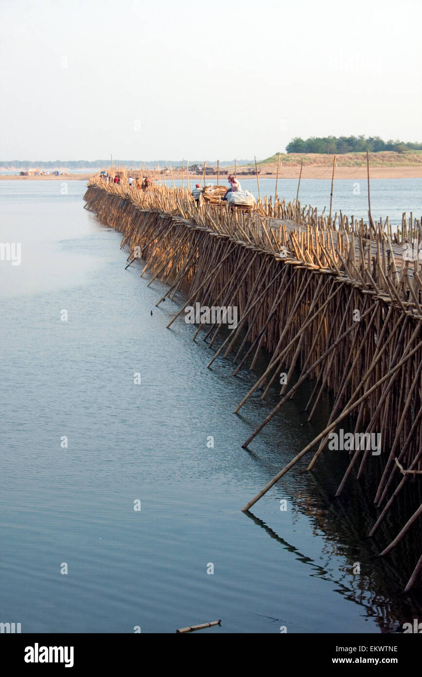 Las personas están cruzando un puente de bambú que se extiende sobre el río Mekong en Kampong Cham, Camboya. Foto de stock