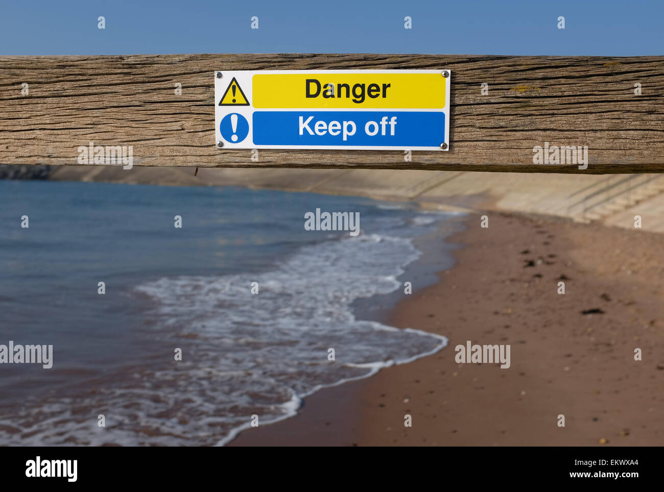 Mantener fuera de peligro en un signo groyn en una playa en Dawlish Warren Devon, Inglaterra Foto de stock