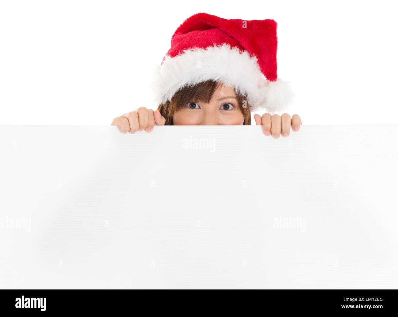 Chica asiática en Santa peeking sobre papel letrero Foto de stock