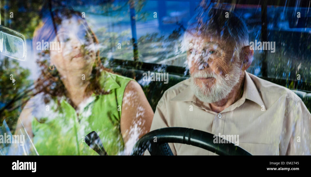 Una mujer de mediana edad y un anciano sentado dentro de la cabina de un camión Foto de stock
