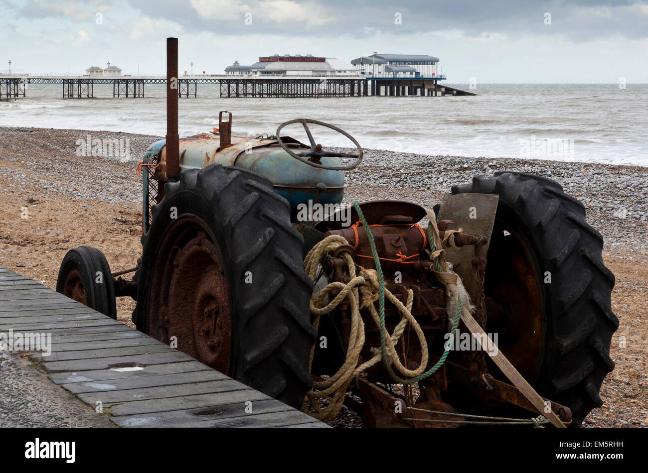 Un viejo tractor vintage usados en la industria pesquera de pie en la playa en Cromer, Norfolk UK Foto de stock