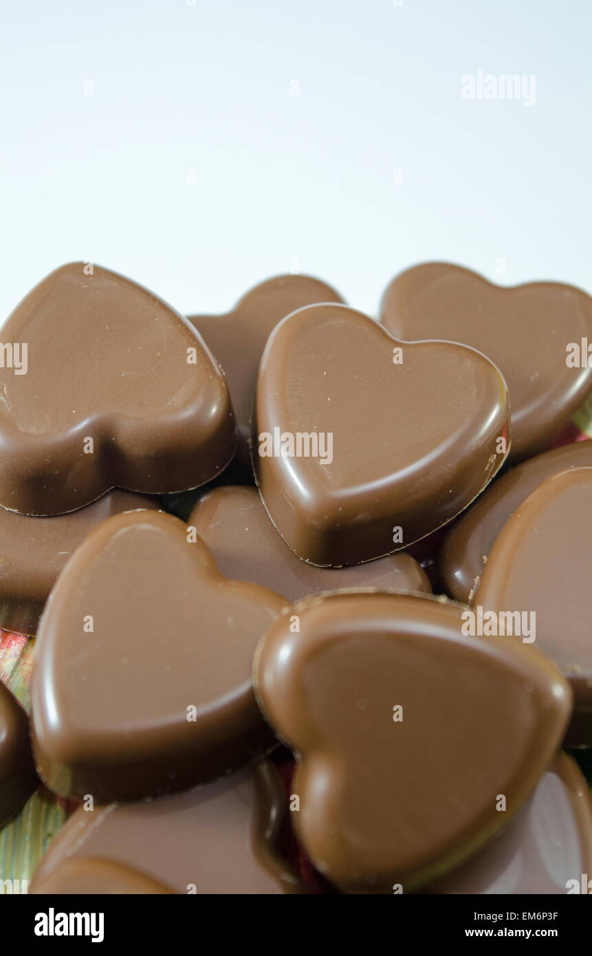 Deliciosamente buscando chocolate en forma de corazón sobre fondo blanco. Foto de stock