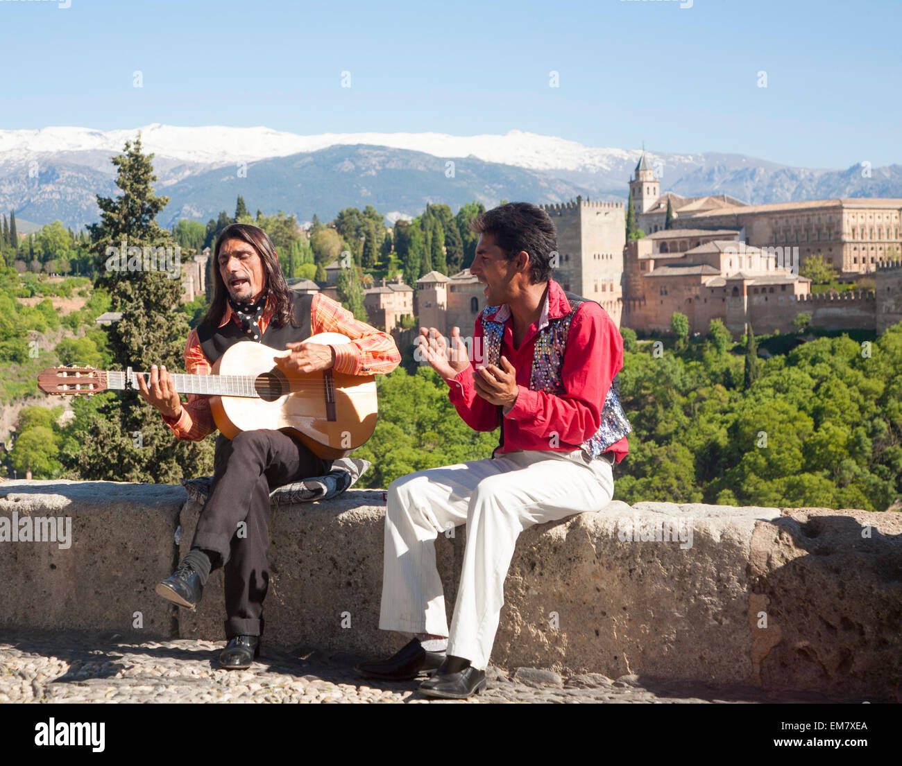 Músicos flamencos jugar con un telón de fondo de la Alhambra y Sierra Nevada y coronado de nieve, Granada, España Foto de stock
