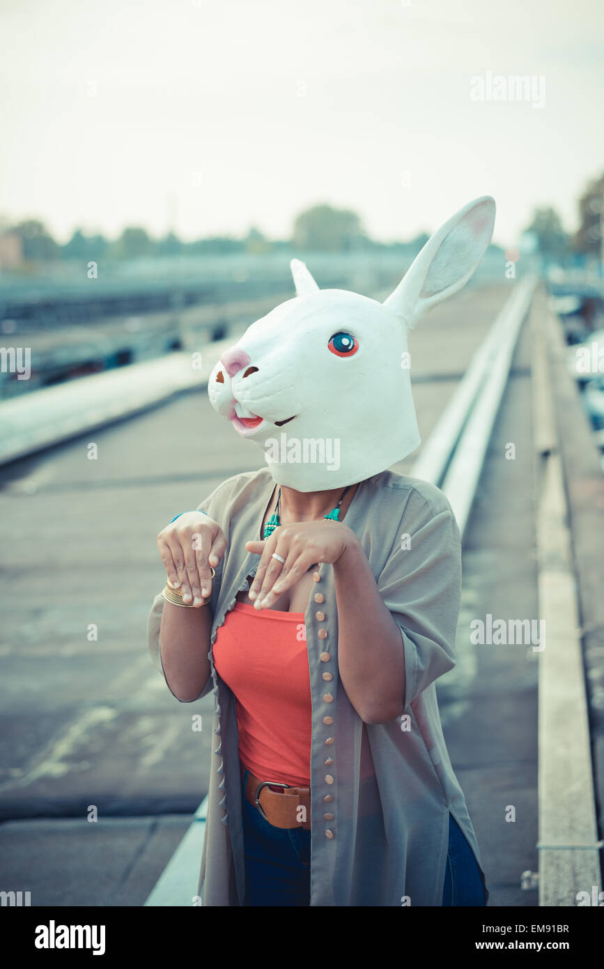 Mujer joven en traje de conejo en la zona industrial de la ciudad de máscara Foto de stock
