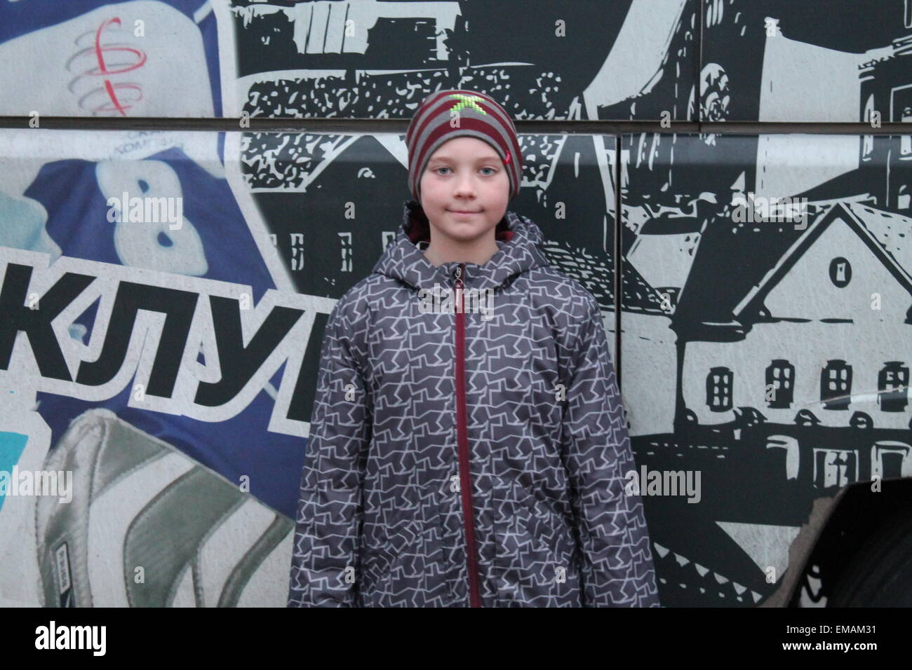 Hermoso deporte sonriente niño permanecer detrás del autobús, en marzo, en Minsk, 2015 Foto de stock
