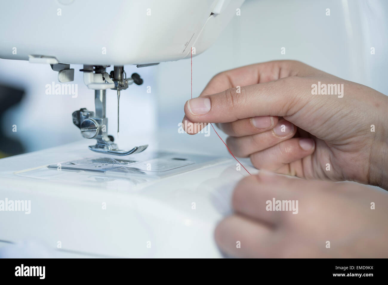 Esquivo Transparente pintar Close-up de mujer poner hilo en una máquina de coser Fotografía de stock -  Alamy