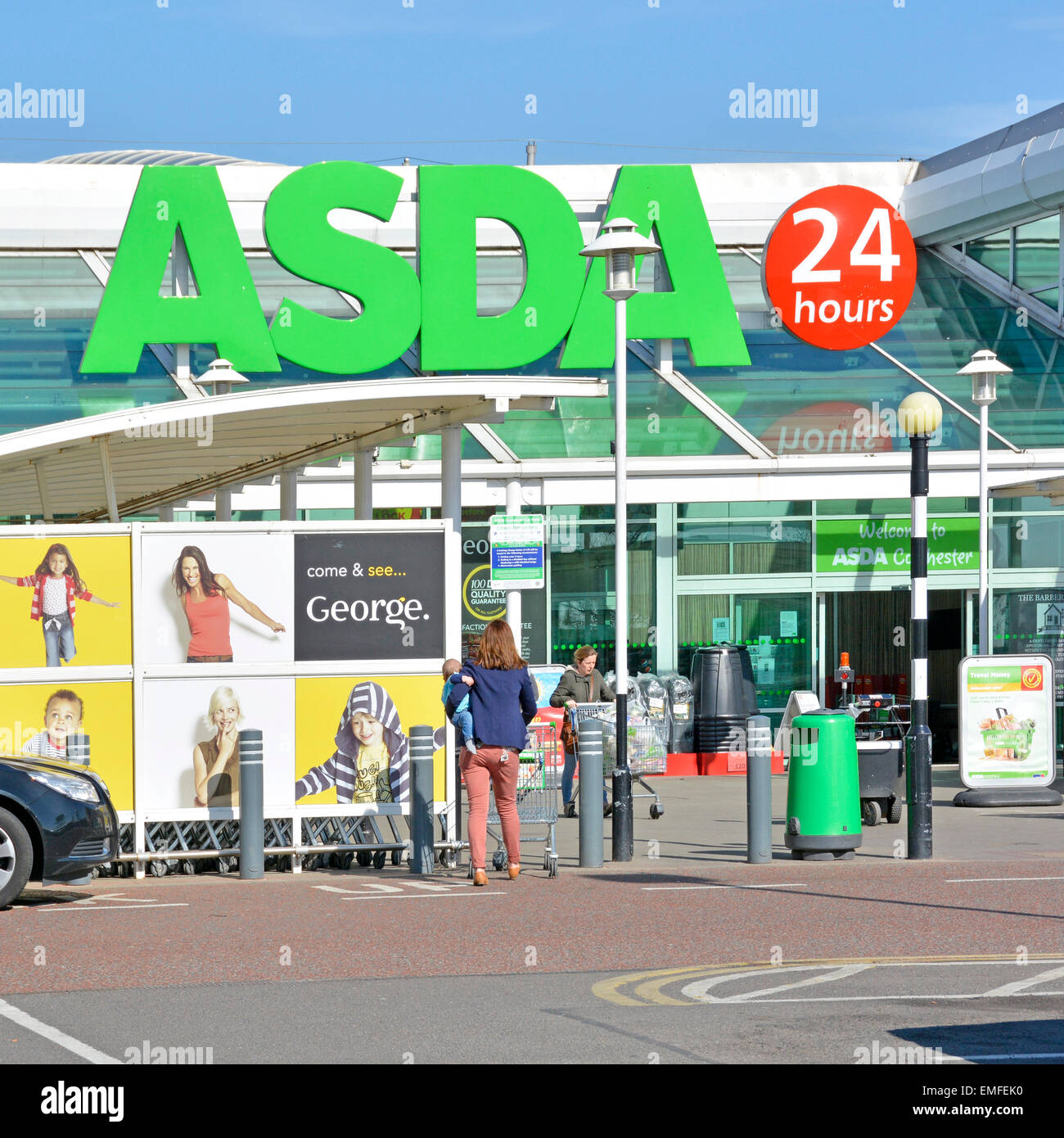 Compradores en la entrada principal de la comida Asda y George supermercado tiendas de venta por menor negocio con 24 horas signo Colchester Essex Inglaterra Reino Unido Fotografía de stock -