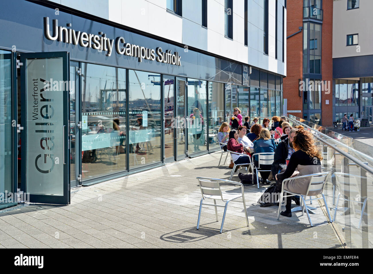 Campus de la Universidad Suffolk personas en mesas y sillas de café al aire libre Y entrada a la Galería Ipswich frente al mar Suffolk England UK Foto de stock