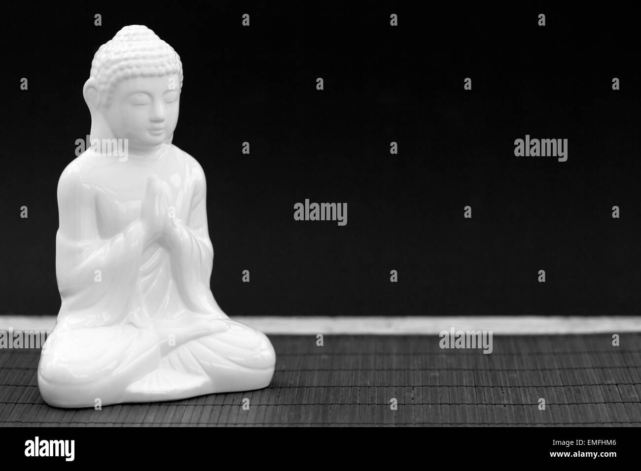 Rodada en blanco y negro horizontal de una figura blanca en pose de meditación Foto de stock