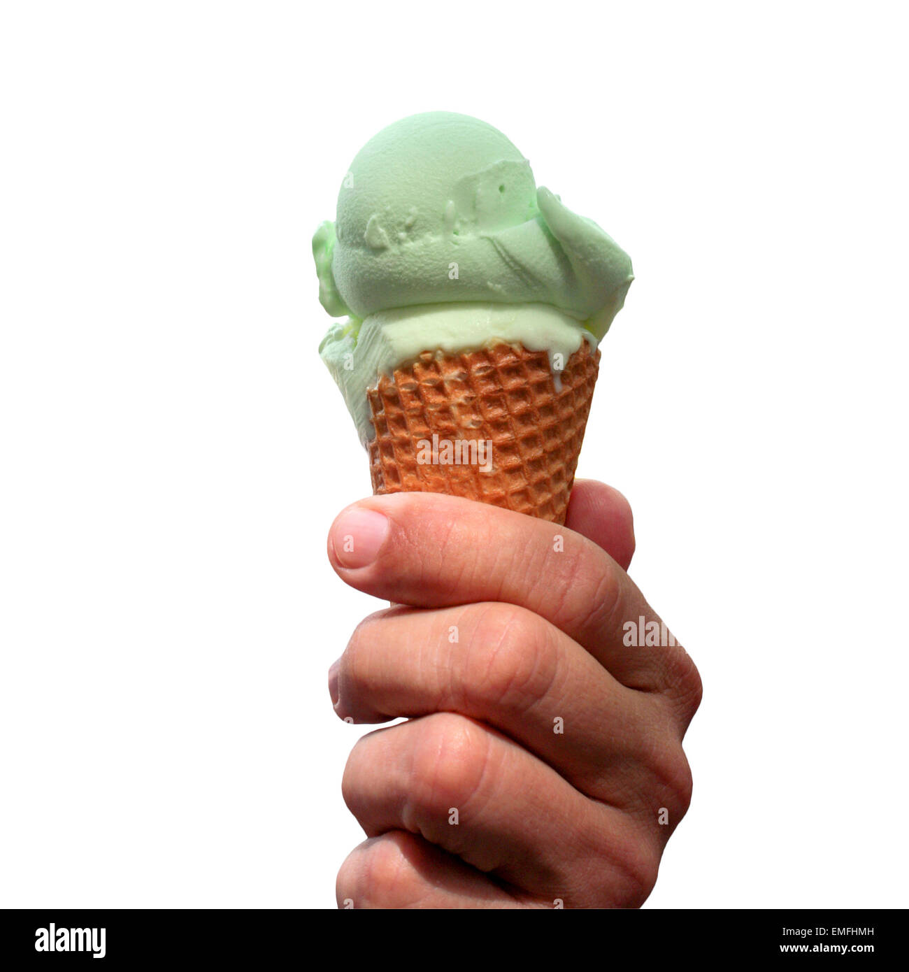 Hombre mano sostiene un cono con helado de pistacho aislado en blanco Foto de stock