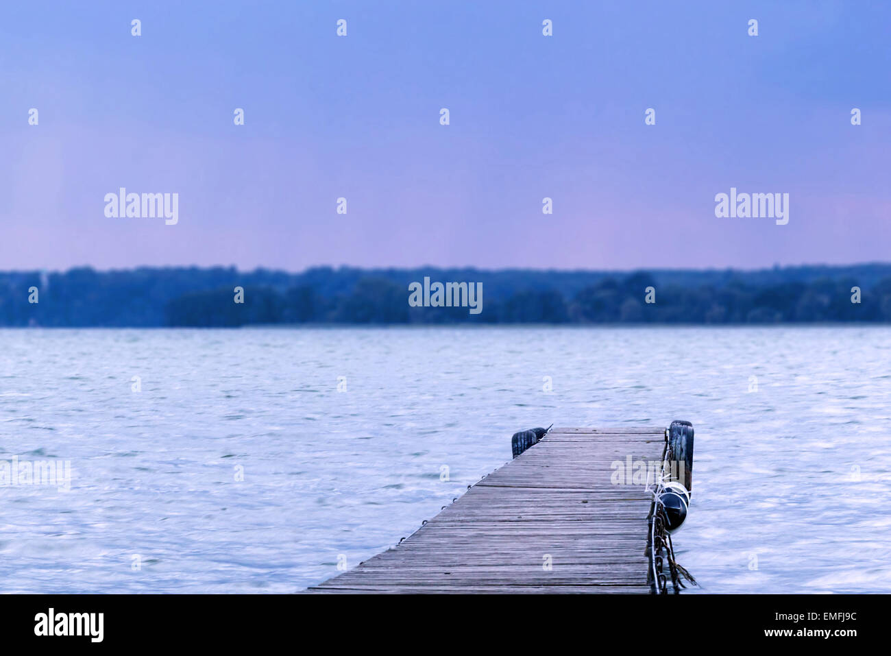 Soñador tilt-shift fotografía de un muelle que lleva al lago Foto de stock