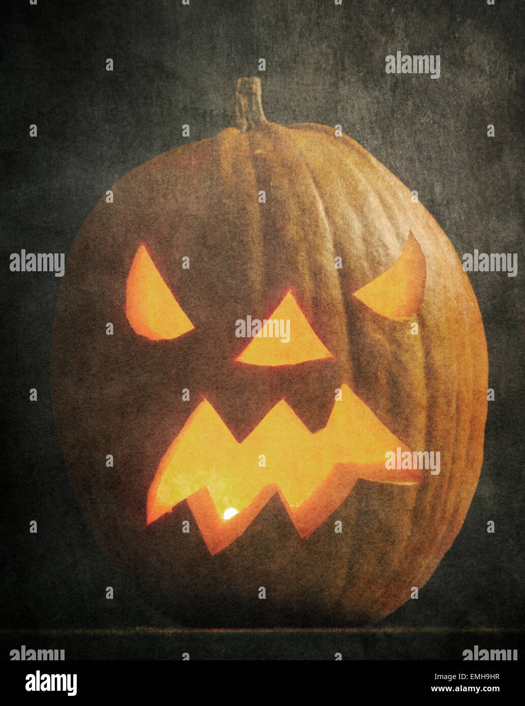 Calabaza de halloween iluminado con fondo oscuro y el efecto de textura. Foto de stock
