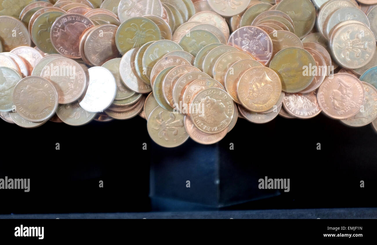 Dos peniques monedas en un punto de inflexión en una máquina arcade costera Foto de stock