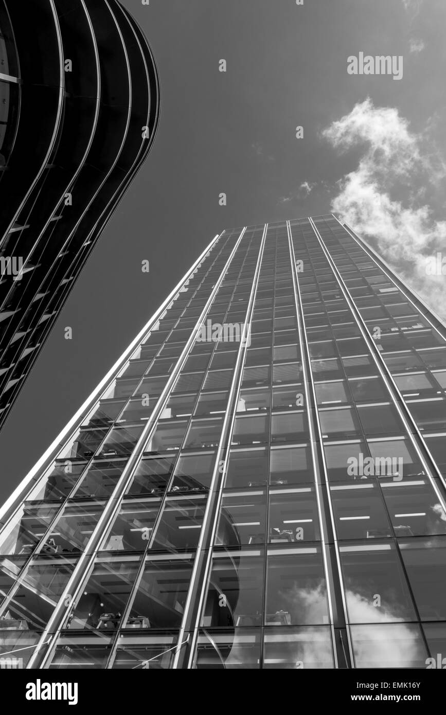 Rodada en blanco y negro de un bloque de oficinas de gran altura en Old Broad Street, Londres, con reflejos en las ventanas de vidrio Foto de stock