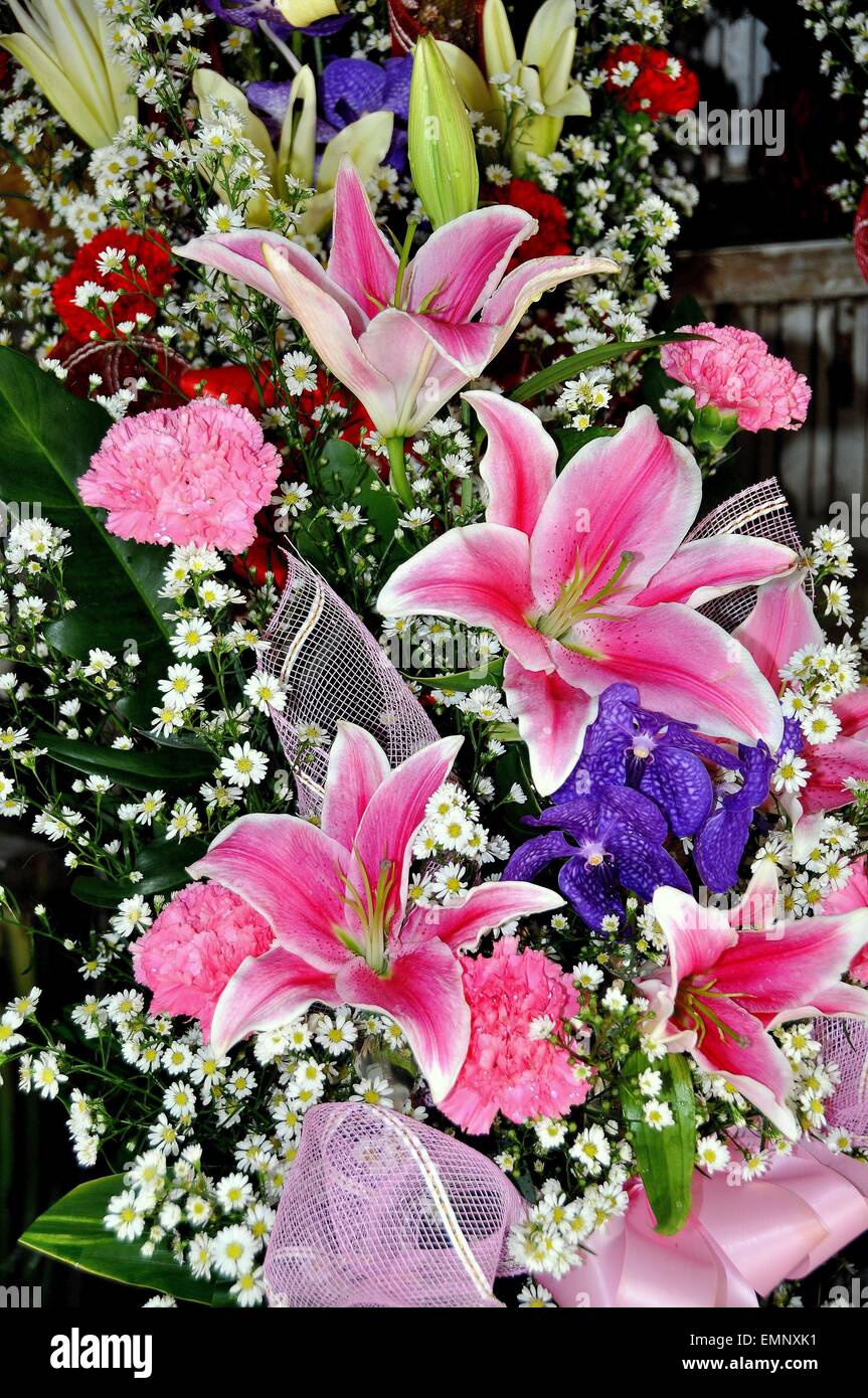 Bangkok, Tailandia: un arreglo floral de lirios Stargazer rosa, violeta,  orquídeas, claveles, rosas y margaritas blancas Fotografía de stock - Alamy