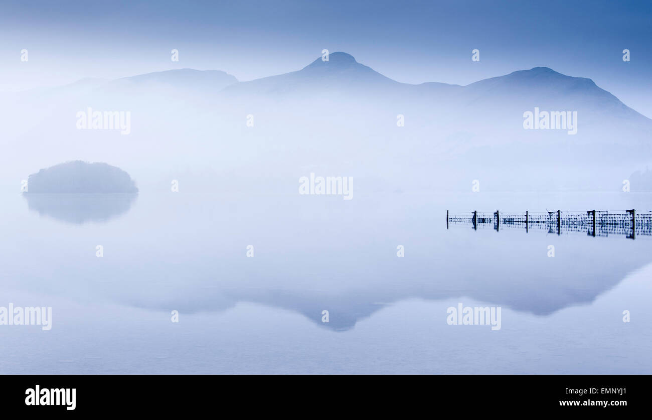 Reflexiones en Derwentwater en una mañana brumosa, Lake District, Inglaterra Foto de stock