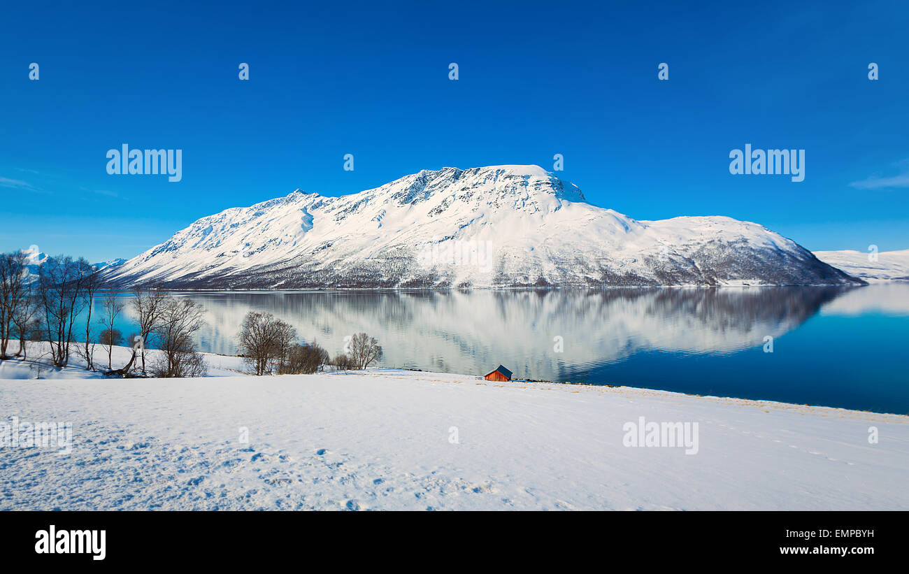 Un soleado paisaje noruego con cielos azules y nevados de la cordillera. Foto de stock
